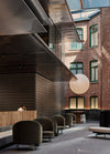 All textures and warm colour, the raw red bricks of a neighbouring building are offset by the Jim armchair in a forest green velvet by Arflex and the Container table in wood by Moooi. Photography © Peter Bennetts c/o Hassell.
